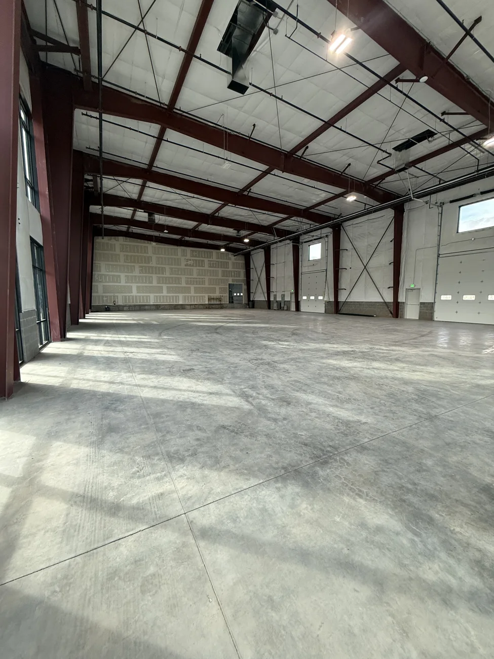 Open steel-framed interior with insulated roof and concrete floor in the Farmington commercial building